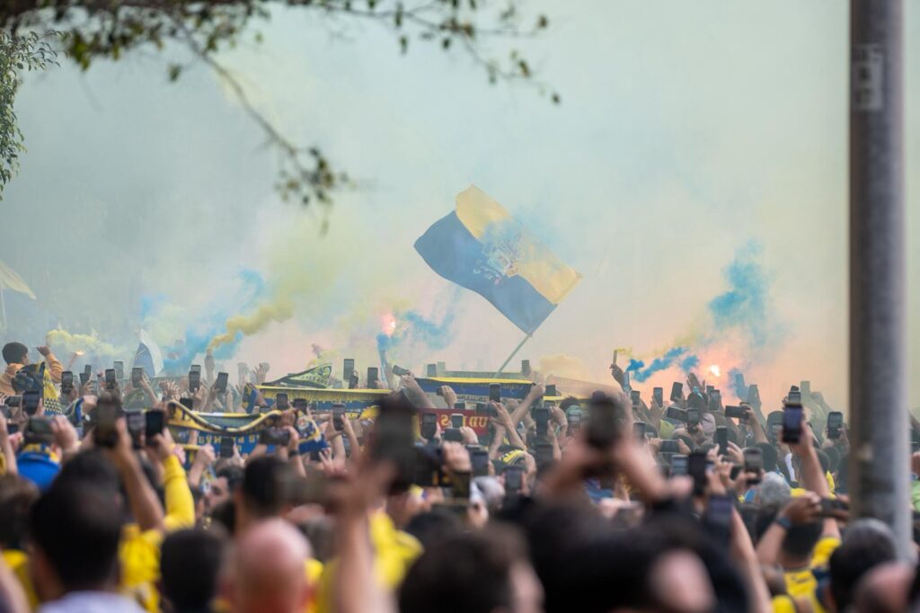 WhatsApp Image 2026-06-07 at 183227 | udlaspalmas.NET FOTOS | Vea la fotogalería del espectacular recibimiento en Fondos de Segura, previo al encuentro ante el Málaga. Una vez más la afición amarillo no defraudó. A las 18:00 horas la marea amarilla se citó en la calle Fondos de Segura, como en los grandes días. Allí los jugadores recibieron el aliento y energía de