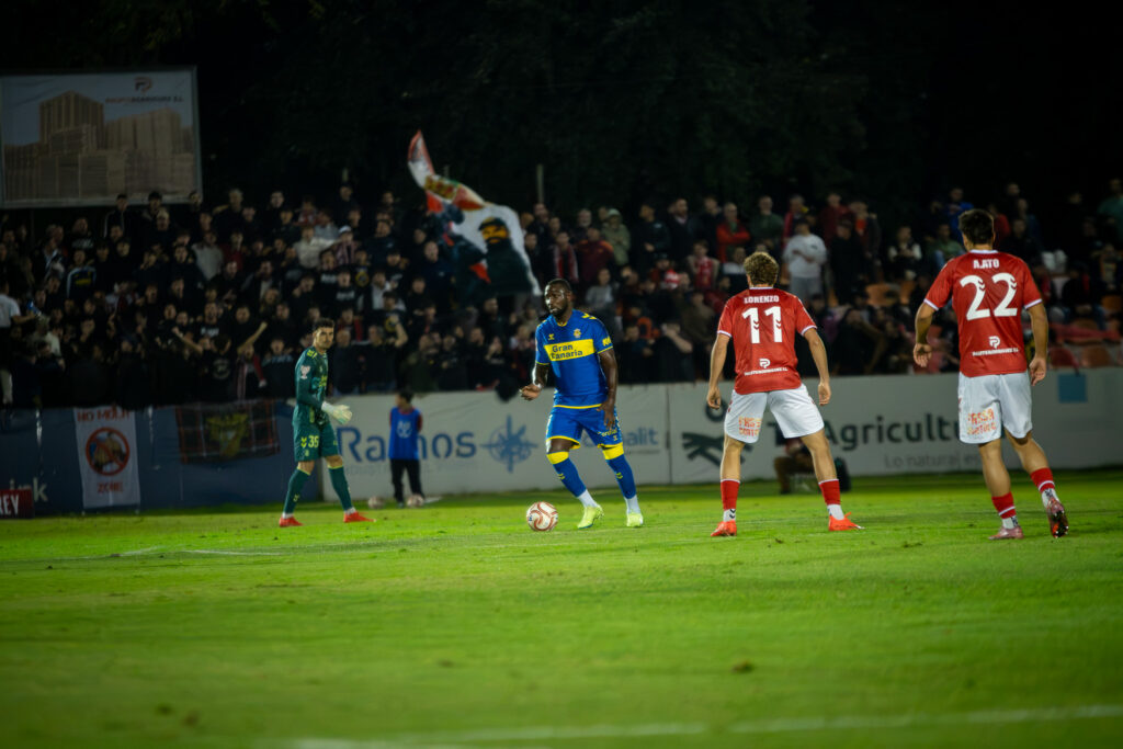 El central ghanés de la Unión Deportiva Las Palmas realizó un partido correcto contra el Alcalá en un partido donde se impuso a nivel físico pero que también deja dudas para el fútbol profesional. Nicholas Opoku llegó a la Unión Deportiva Las Palmas como un central que iba a dar un "rendimiento inmediato", explicó Luis